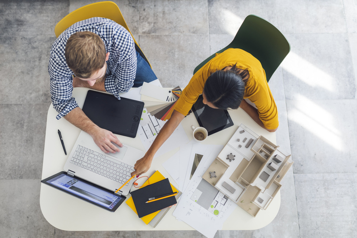 overhead of male and female bisness people discussing over laptop