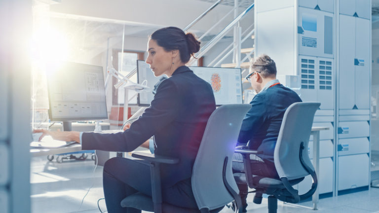 Two employees working on tech in sunlit office